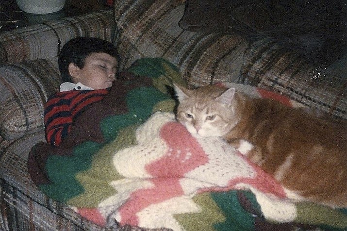 This undated image provided by Jimmy Thyden shows Thyden as a child with cat Rusty. Now 42, Thyden got to embrace his birth mother for the first time during a long-awaited family reunion in Valdivia, Chile in August 2023. His journey to find the birth family he never knew began in April after he read news stories about Chilean-born adoptees who had been reunited with their birth relatives with the help of a Chilean nonprofit Nos Buscamos. While Thyden was successfully reunited with his birth family, he recognizes that reunification might not go as well for other adoptees. (Jimmy Thyden via AP)