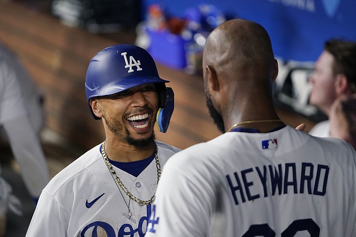 Los Angeles Dodgers' Mookie Betts celebrates with Jason Heyward in the dugout after Betts hit a home run against the Arizona Diamondbacks during the sixth inning of a baseball game Tuesday, Aug. 29, 2023, in Los Angeles. (Ryan Sun/AP)