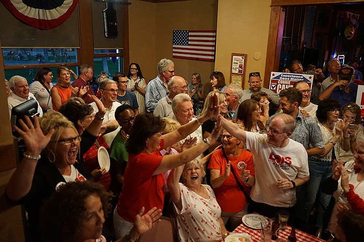 Prescott City Council candidate Lois Fruhwirth (in red shirt) high fives a supporter after the Prescott results were announced during a Primary Election night gathering at the Jersey Lilly Saloon Tuesday, Aug. 1, 2023. Fruhwirth and her supporters gathered with fellow candidates incumbent Mayor Phil Goode, incumbent Councilwoman Cathey Rusing, incumbent Councilwoman Connie Cantelme, and candidate Ted Gambogi to watch the primary results. All five of the candidates appear to have won their seats outright in the Aug. 1 
unofficial results. (Cindy Barks/Courier)