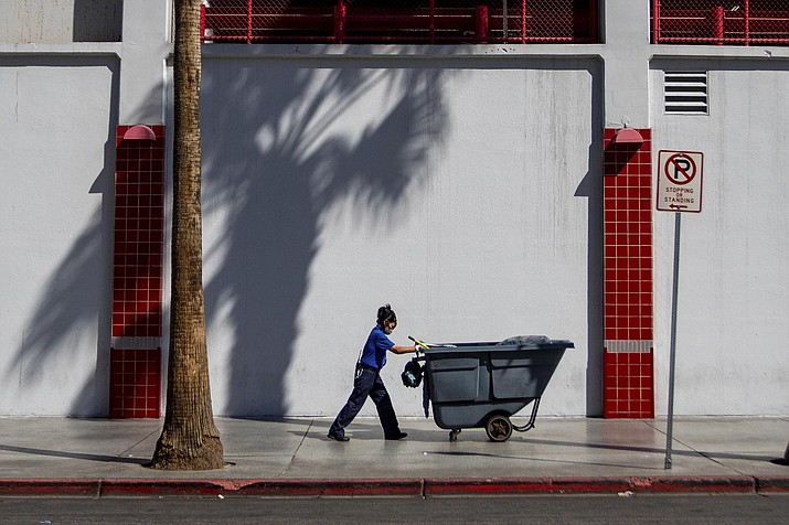 A maintenance worker pushes a refuse cart in the sun, Friday, Aug. 25, 2023, in Las Vegas. A historic heat wave that began blasting the Southwest and other parts of the country this summer is shining a spotlight on one of the harshest, yet least-addressed, effects of climate change in the U.S.: the rising deaths and injuries of people who work in extreme heat, whether inside hot warehouses and kitchens or outside under the blazing sun. Many of them are migrants in low-wage jobs. (Ty O'Neil/AP)