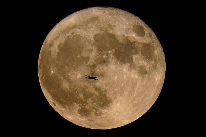 A plane passes in front of a supermoon, July 13, 2022, in Milwaukee. A rare blue supermoon could normal raise tides just as Hurricane Idalia takes aim at Florida’s west coast, exacerbating flooding from the storm. The moon will be closest to the Earth on Wednesday night, Aug. 30, 2023, the same day Idalia is expected to make landfall in Florida. (Morry Gash/AP, File)